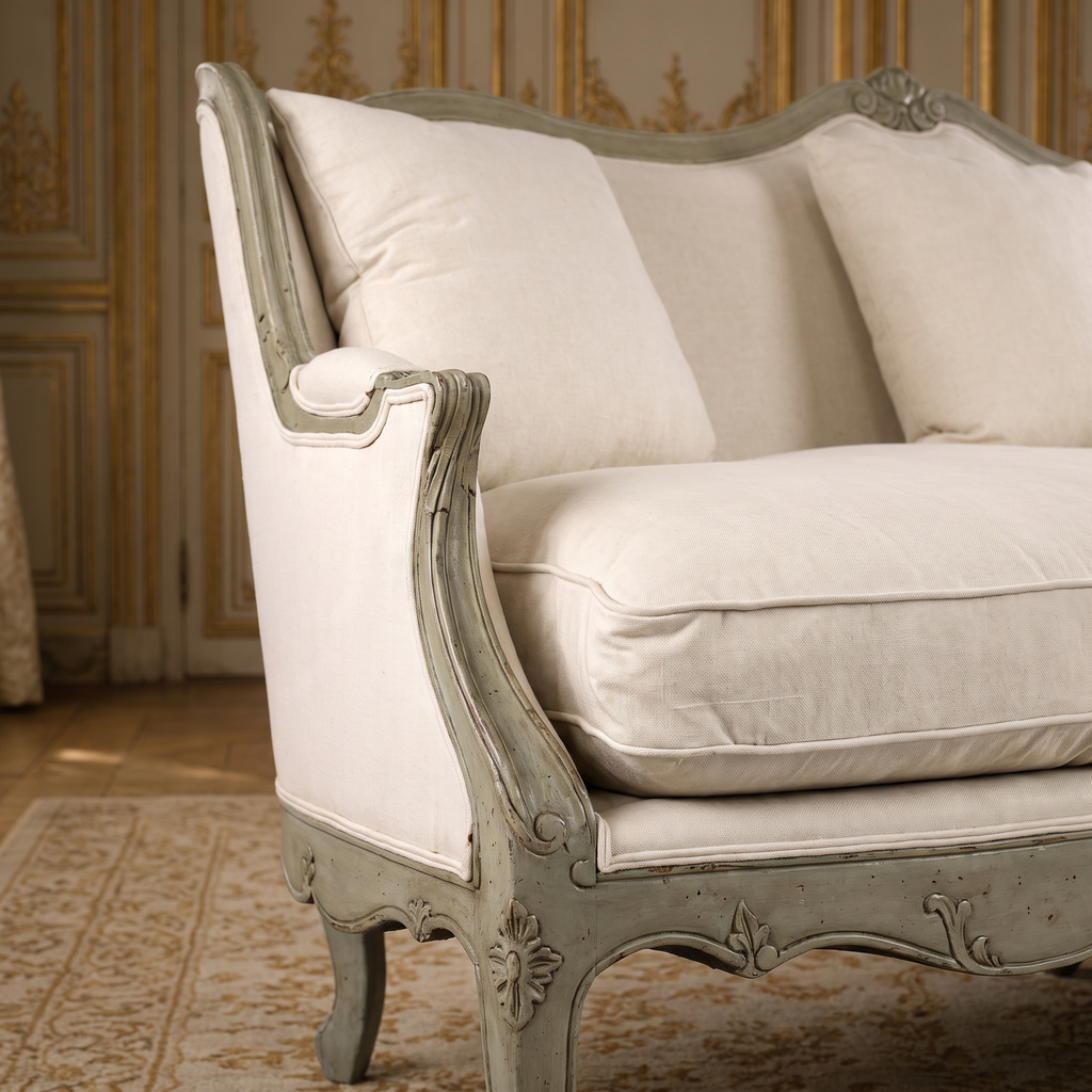 Close view of the carved olive green arm, cotton seat cushion and back pillow of the Adele Carved French Cotton Sofa