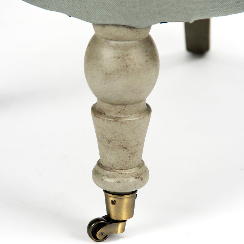 Detail of the turned birch leg and brass caster of the Amelie French Tufted Linen Slipper Chair