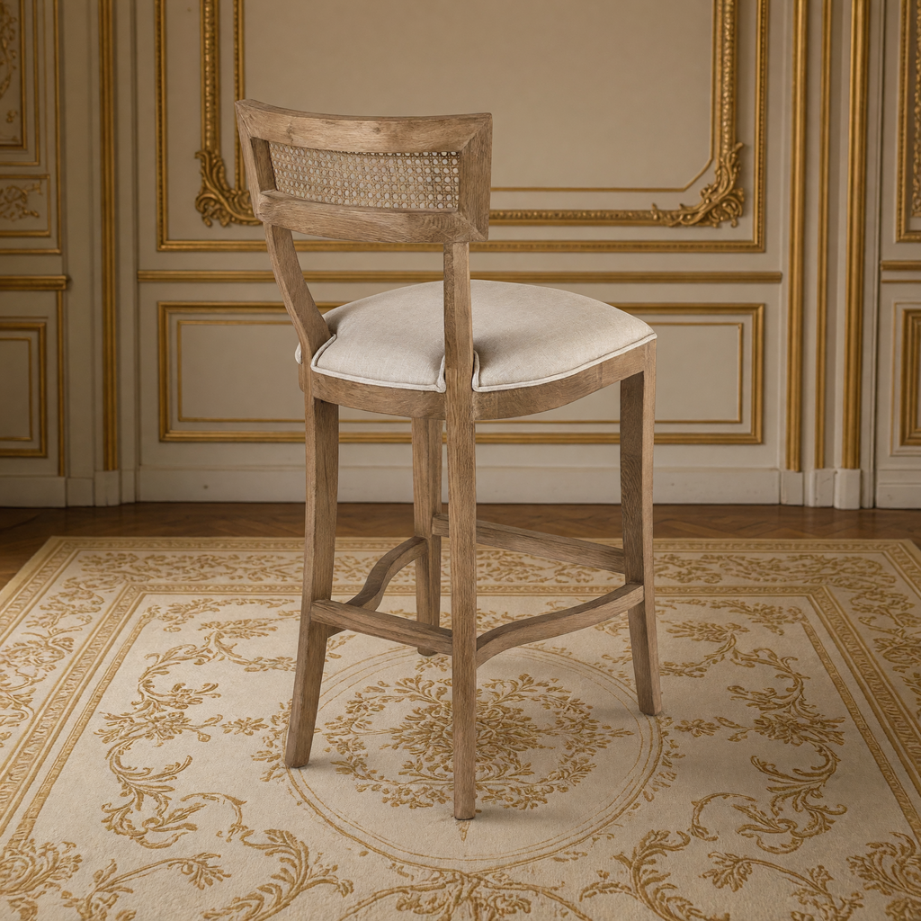 Carvell Cane Back Oak Bar Stool in Natural Linen, Solid Oak, rear three-quarter view showing the cane back, in a French salon