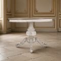 Chandler round pedestal dining table in a gilded boiserie room on an antique limestone floor