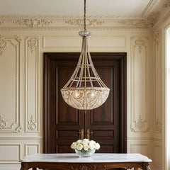 Elizabethan K9 crystal chandelier hanging in an entryway above a marble console table