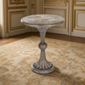 Fabiola French Carved Wood Pedestal Side Table in Weathered Grey Birch in a gilded French salon