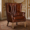 George channelled leather wingback chair in Newark Brown in a gilded ivory French salon