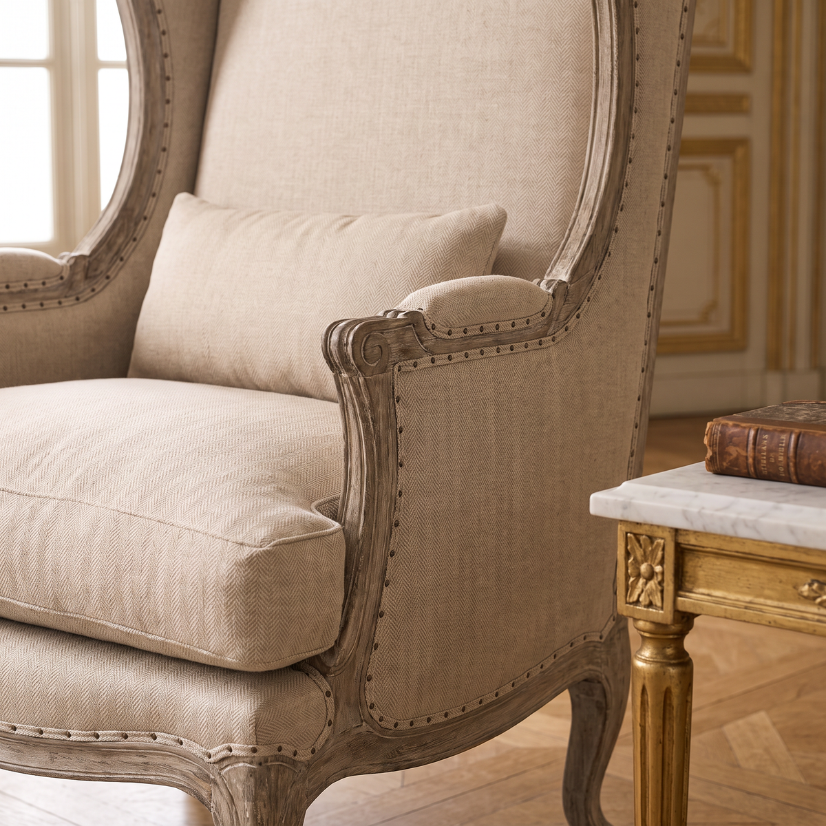 Close-up of the scrolled arm, nailhead trim and hemp linen cushions of the Leon French Hemp Linen Wingback Chair