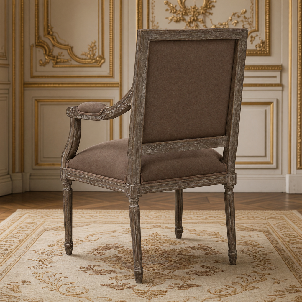 Back view of the Louis French carved oak square-back arm chair in Chestnut Clay Linen, limed charcoal oak, in the same gilded salon