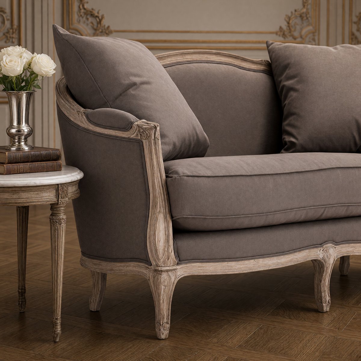 Close view of the aubergine linen and carved limed oak arm of the Maison settee