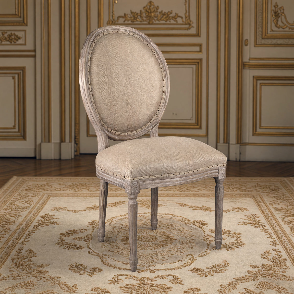 Medallion French oval-back side chair in hemp, limed grey oak in a gilded Louis XVI salon on an Aubusson carpet