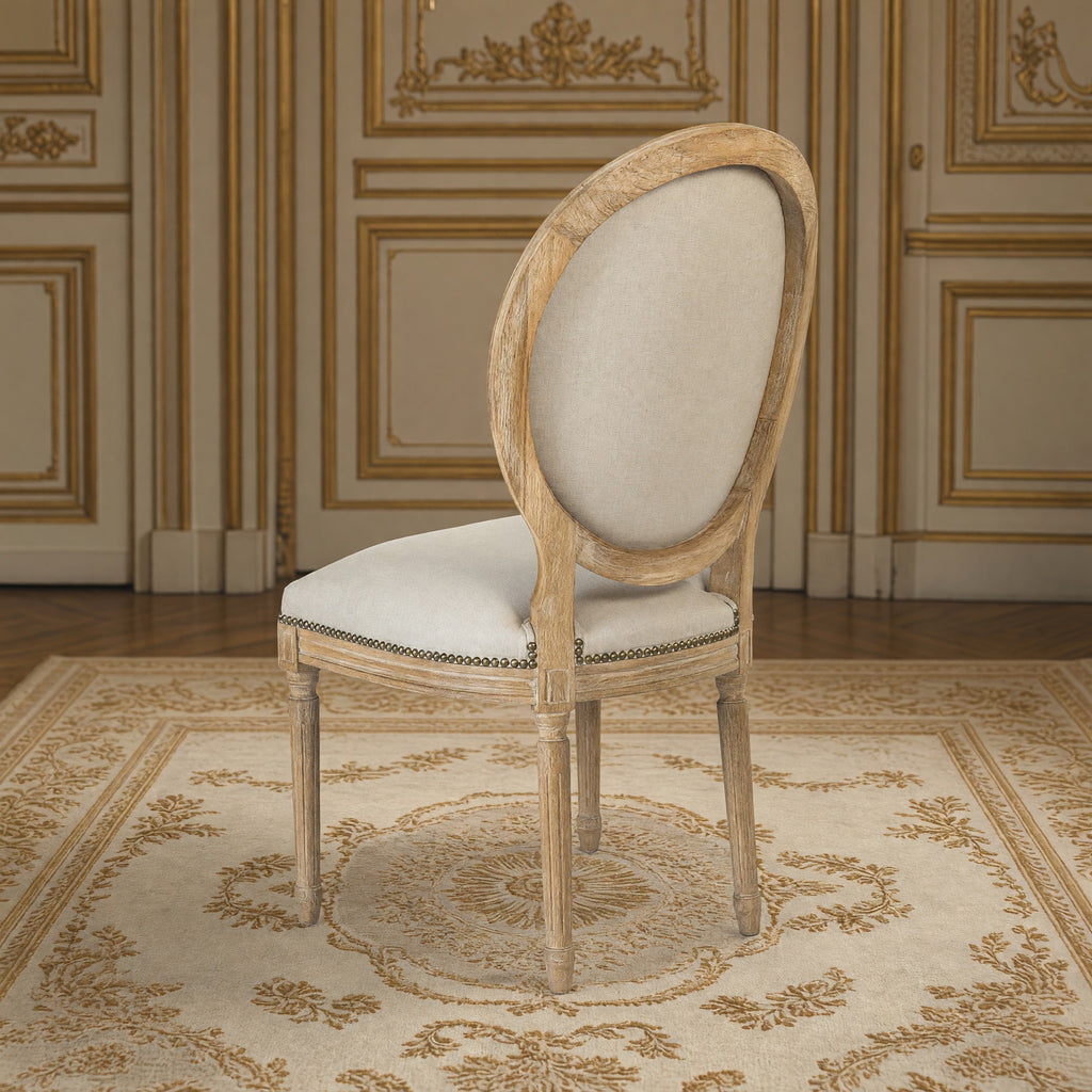 Rear three-quarter view of the Medallion side chair in natural linen with nailhead trim on limed grey oak