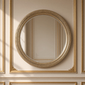 Mael antiqued metal round wall mirror in silver-gold hanging on a gilded taupe boiserie wall