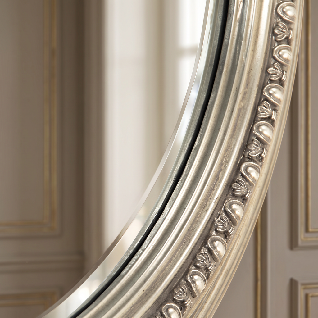 Detail of the egg-and-dart beaded border and beveled glass of the Ecran round mirror in antiqued silver