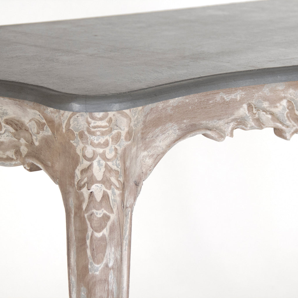 Close-up of the Reuben console's slate grey top and carved limed white leg