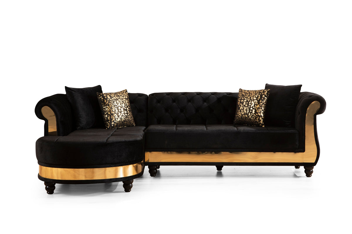 Tufted velvet L-shaped sectional in black, front view with chaise and gold base on white background